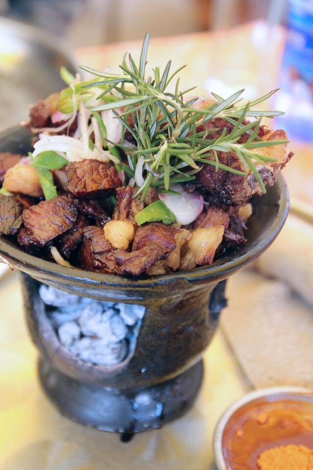 Traditional Ethiopian tibs with grilled beef, onions, herbs, and spices served in a hot clay pot at Abyssinia Restaurant Lausanne