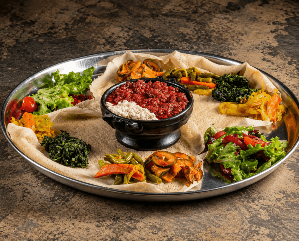 Homemade ethiopian kitfo served with traditional injera bread and fresh seasonal ingredients at Abyssinia Restaurant
