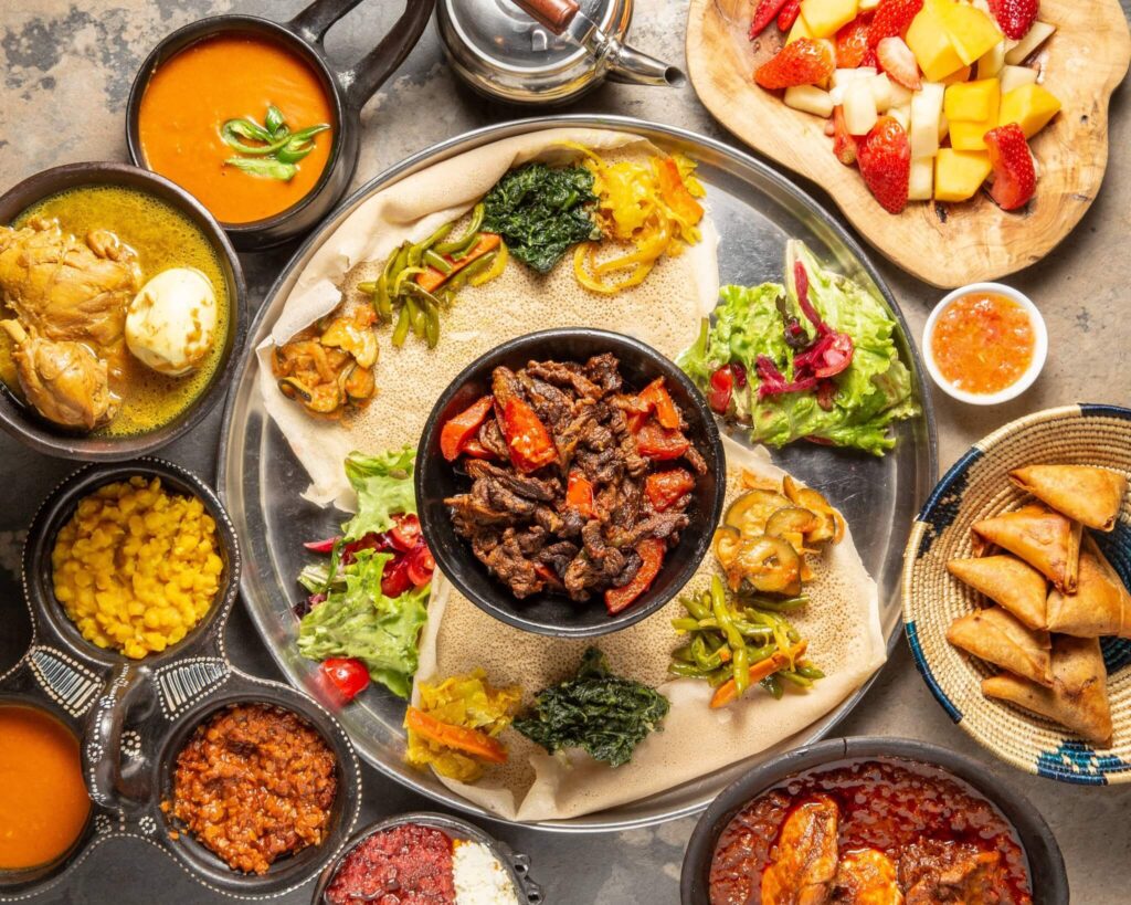 Traditional Ethiopian, Eritrean, and Indian sharing platter with injera, grilled beef, fresh vegetables, lentils, and homemade specialties at Abyssinia Restaurant Neuchâtel