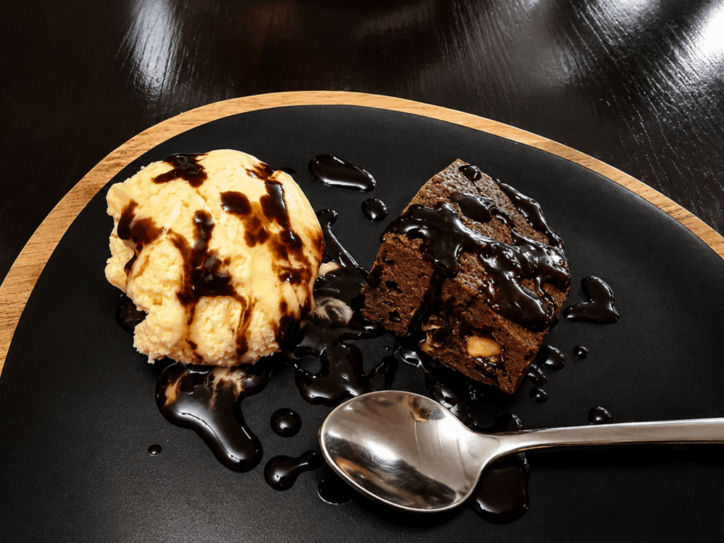 Homemade chocolate brownie with vanilla ice cream and chocolate sauce served at Abyssinia Ethiopian, Eritrean, and Indian Restaurant Neuchâtel