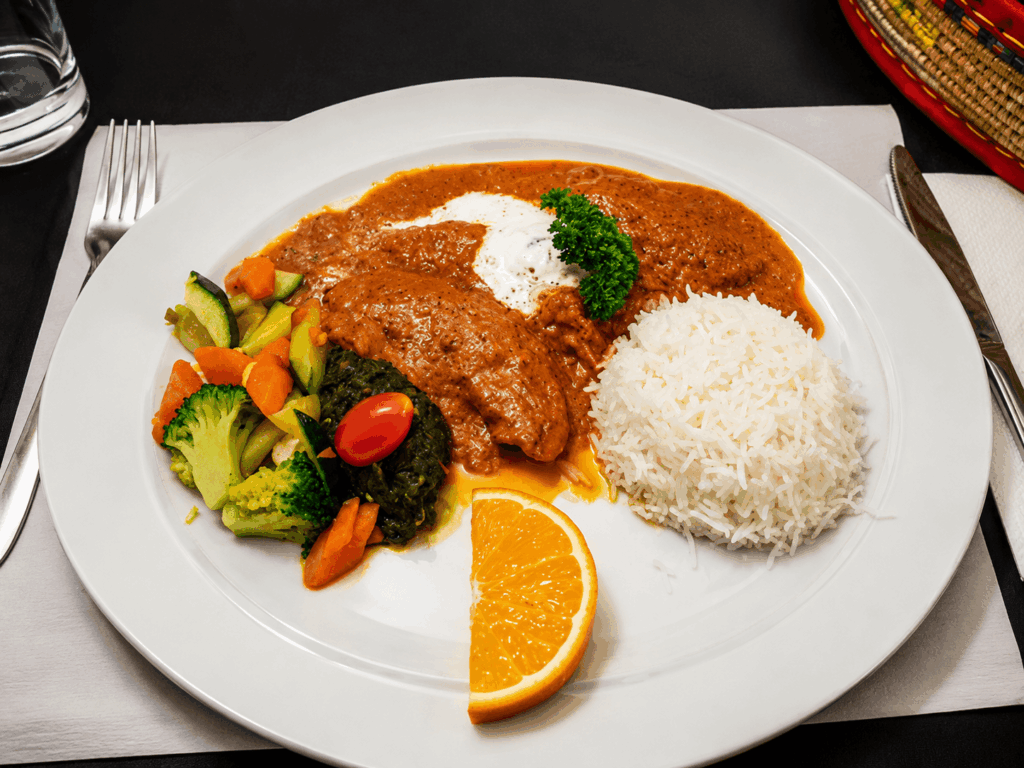 Authentic Indian curry served with basmati rice, fresh vegetables, and aromatic spices at Abyssinia Restaurant in Neuchâtel