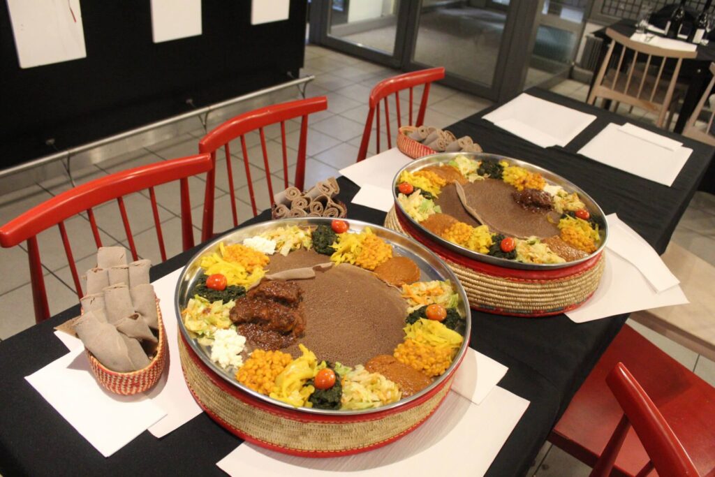 Traditional Ethiopian messob dining experience with injera, vegetarian dishes, stews, and communal sharing platters at Abyssinia Neuchâtel
