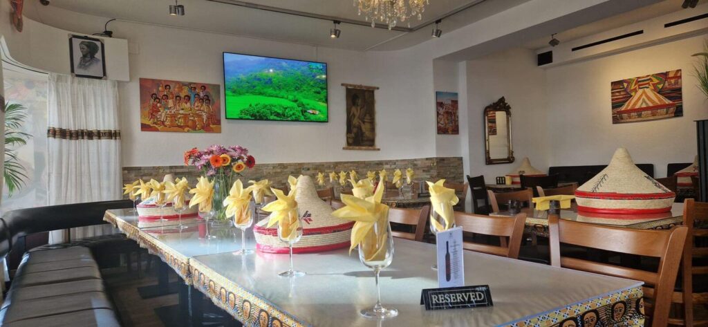 Warm and welcoming interior dining area of Addis Abeba Ethiopian Restaurant in Zürich with traditional East African decor