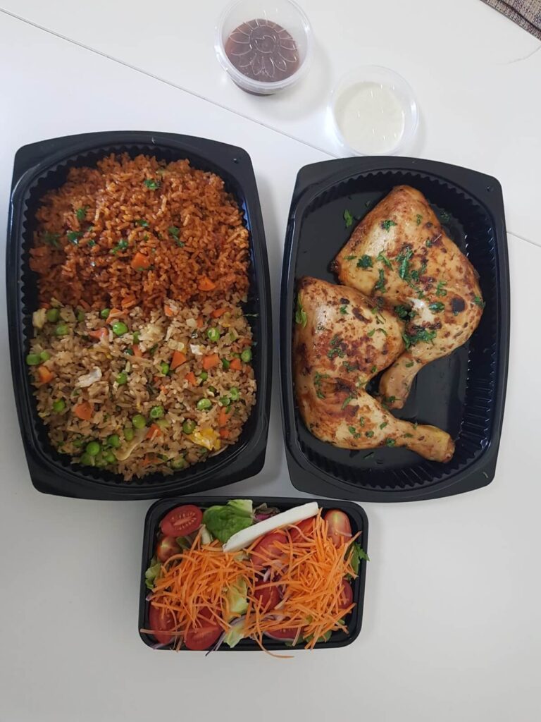 Flavorful Jollof rice served with grilled chicken, fresh salad, and homemade dressing from AfroSwiss Cuisine African food delivery service in Geneva