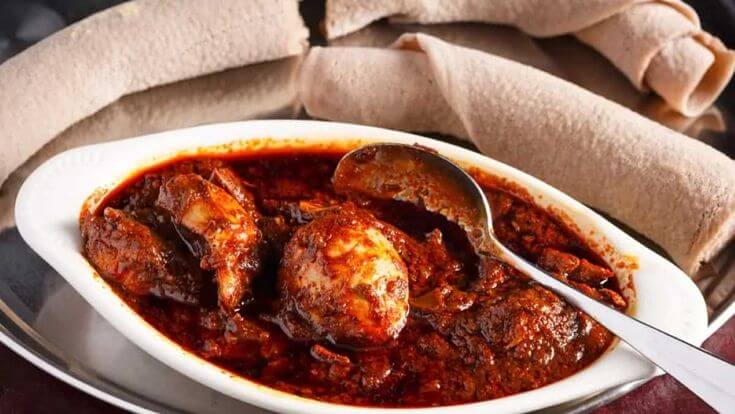 Traditional doro wat with spicy Ethiopian chicken stew, boiled eggs, and fresh injera at Savanna Eritrean & Ethiopian Restaurant
