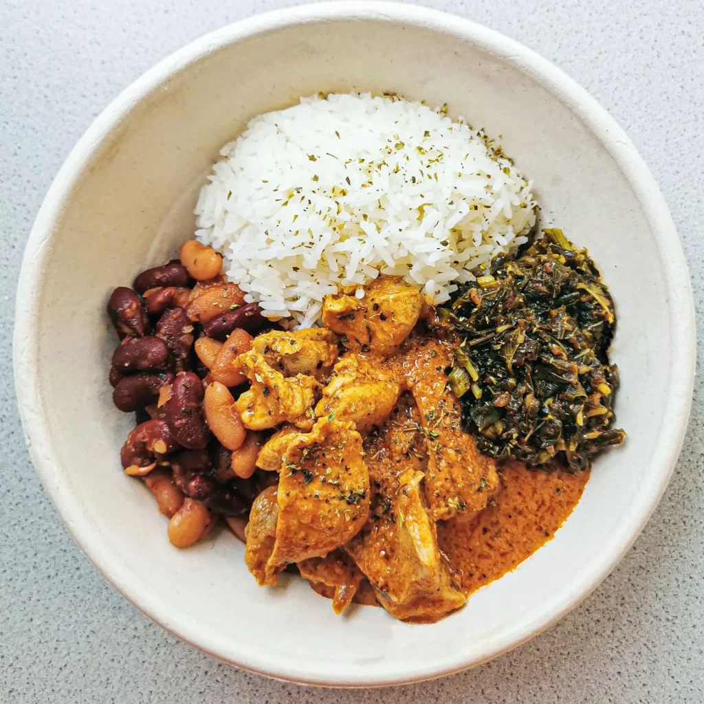 Traditional Congolese chicken in peanut sauce with rice, beans, and greens at BOMOZIKA Zürich