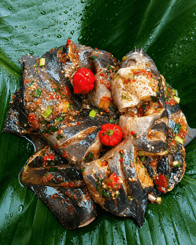 Spicy marinated catfish prepared by Cook-Yamo with traditional African spices and fresh herbs in Switzerland