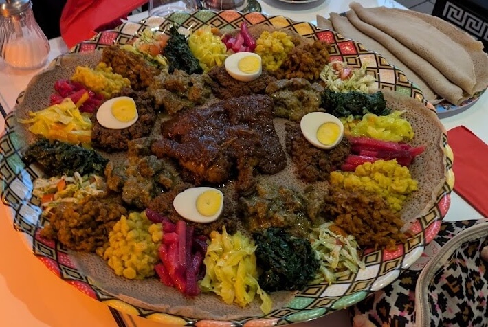 Traditional Ethiopian Doro Wat chicken stew served with injera and vegetable sides at Liyu Restaurant Zürich
