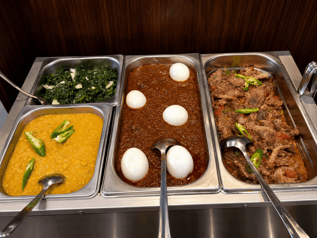 Selection of Ethiopian and Eritrean homemade dishes including lentils, spinach, beef, and eggs prepared at Ge’ez Restaurant Lausanne