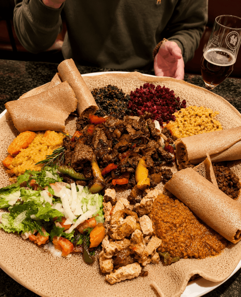 Traditional Ethiopian injera sharing platter with lentils, vegetables, and homemade specialties at Lalibela Restaurant Basel