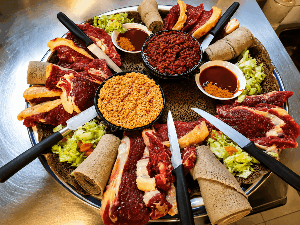 Ethiopian raw meat specialties with lentils, spinach, cabbage, and injera served at Lalibela Restaurant in Basel