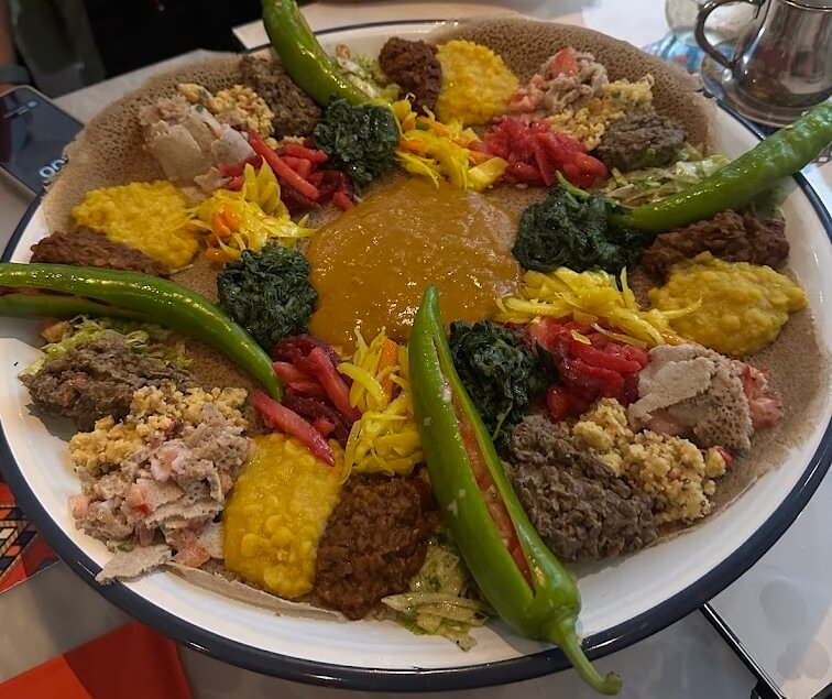 Ethiopian vegetarian injera platter with lentils, spinach, vegetables, and homemade East African specialties at Liyu Restaurant Zürich