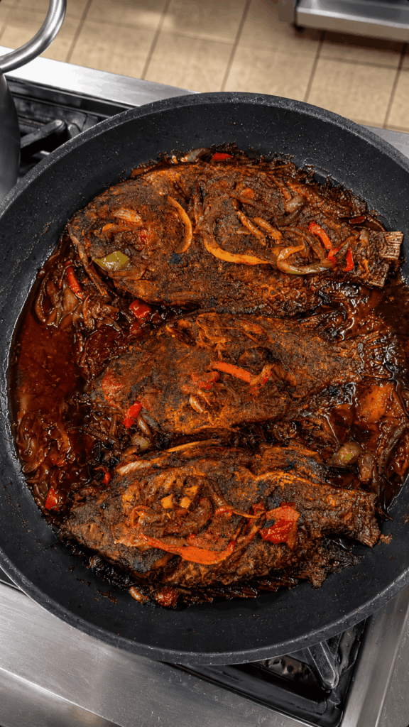 African braised fish cooked in spicy tomato sauce with onions and peppers at Chez Bonaventure Lausanne