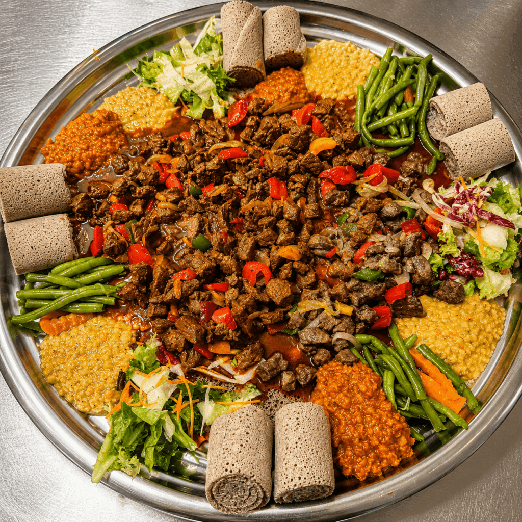 t: Flavorful Eritrean beef tibs platter with injera, lentils, vegetables, and East African spices served in Switzerland