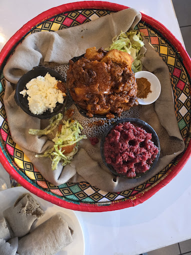 Traditional Ethiopian kitfo meat specialty served with injera and aromatic spices at Liyu Restaurant in Zürich