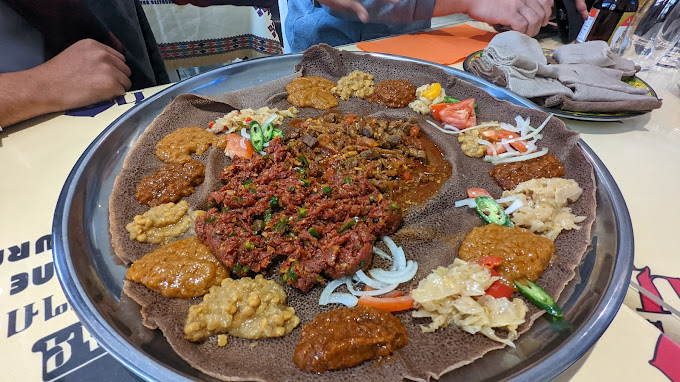 Authentic Habesha platter featuring kitfo, injera, traditional sauces, and Ethiopian specialties at Mama Cuisine Habesha