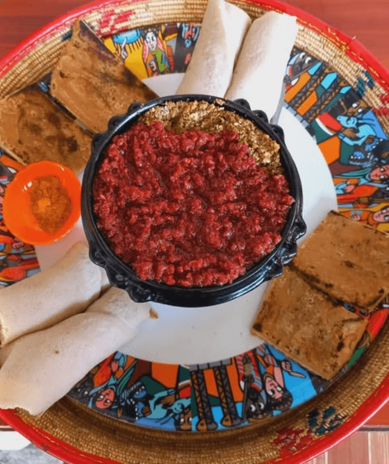 Authentic Ethiopian and Eritrean kitfo served with injera, spices, and fresh beef at Mercato Restaurant