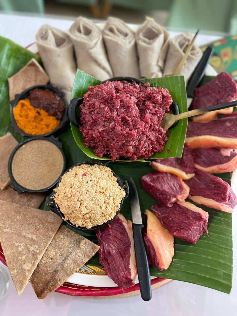 Traditional spicy kitfo beef specialty with injera and East African spices at Mercato Restaurant