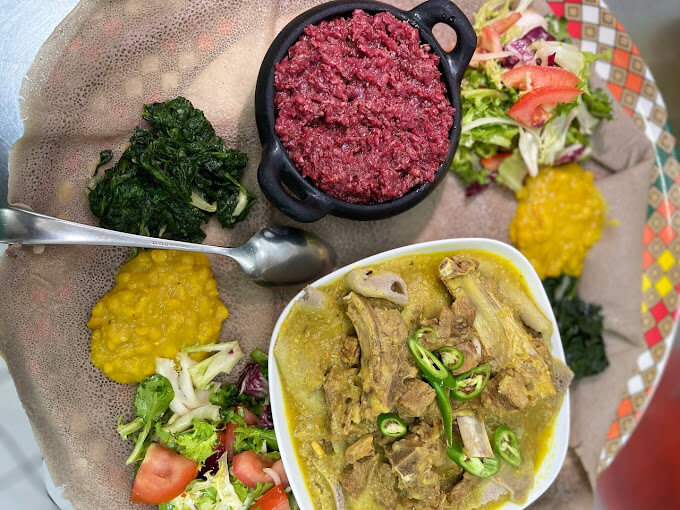 Traditional spicy kitfo beef specialty with injera and East African spices at Mercato Restaurant