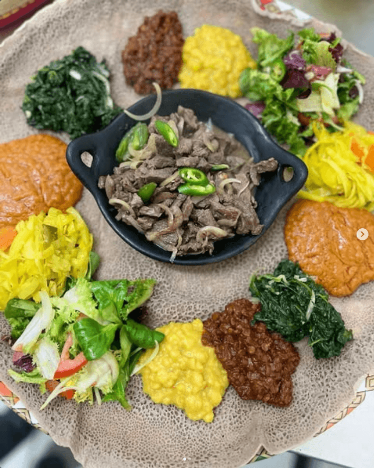 Ethiopian and Eritrean tibs beef platter with injera, lentils, vegetables, and fresh salad at Mercato Restaurant