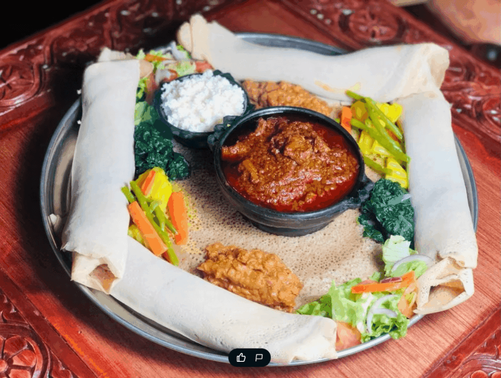 Colorful vegan Eritrean injera platter served at Hidmona Restaurant Geneva