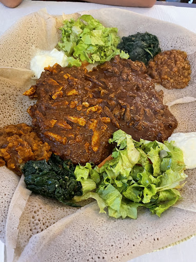 Traditional Eritrean sharing platter with injera and homemade African specialties at Mosaique Geneva