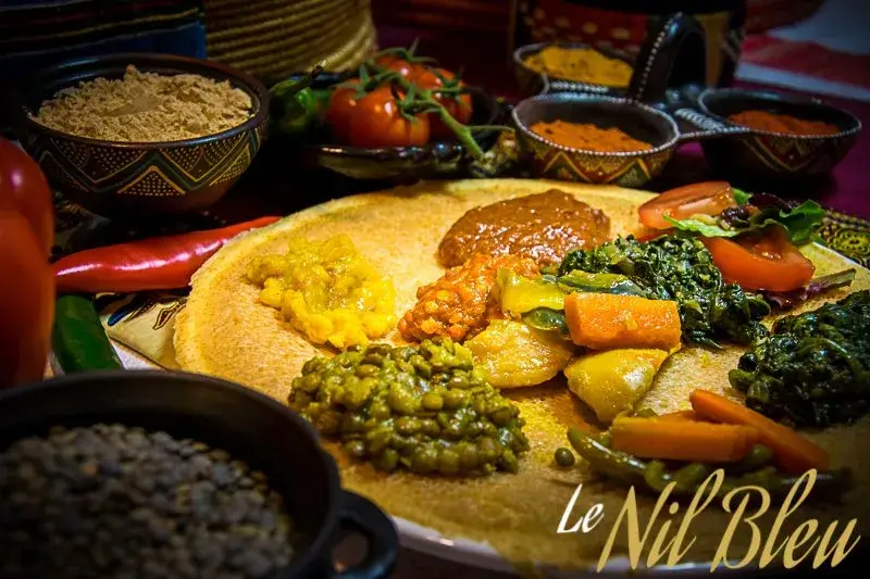 Ethiopian vegetarian injera platter with lentils, spinach, vegetables, and homemade East African specialties at Nil Bleu Lausanne