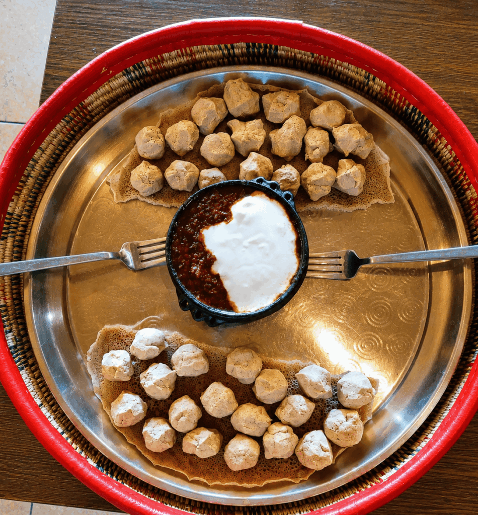 Eritrean homemade dessert specialty served with traditional sauce and injera presentation at Raena restaurant