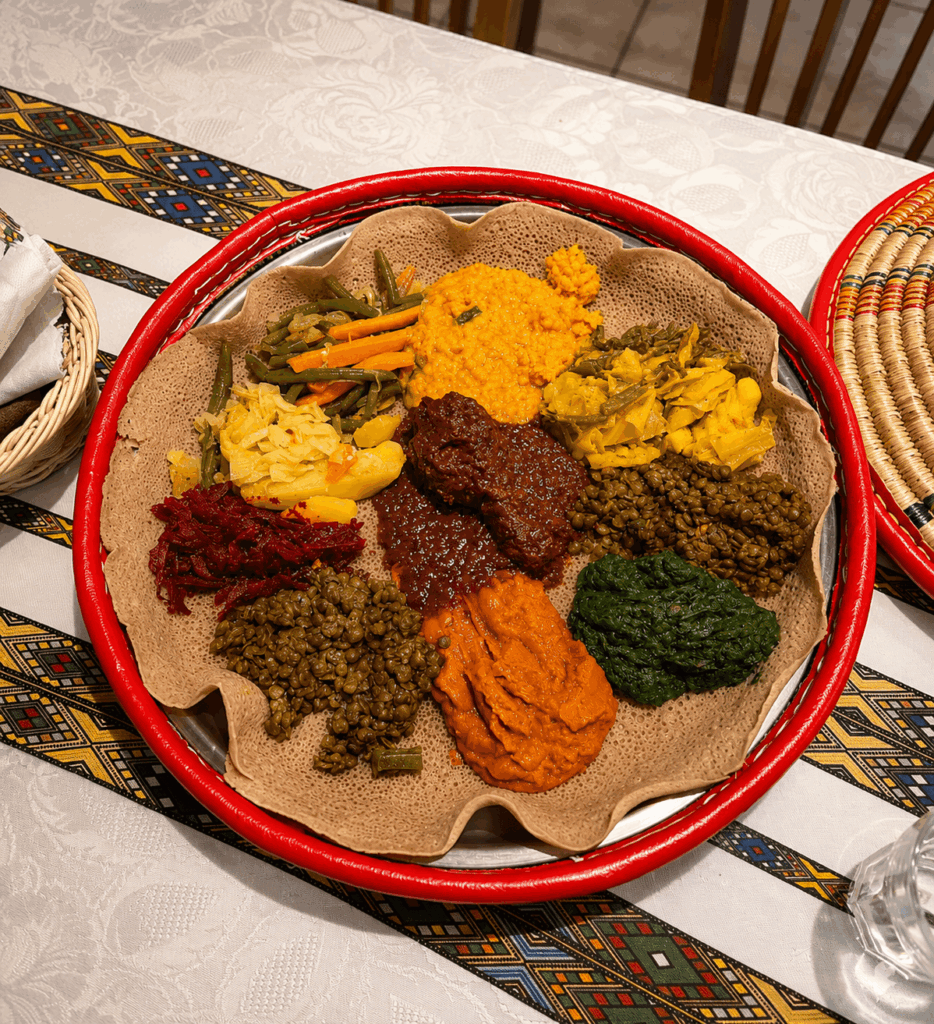 Family-style Eritrean and Ethiopian injera platter with traditional vegetables and meat dishes at Red Sea Restaurant Habesha St. Gallen