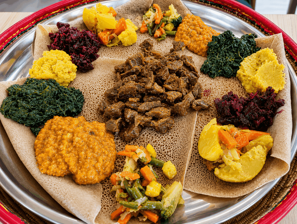 Ethiopian vegetarian injera platter with misir, spinach, vegetables, and traditional homemade East African dishes at Savanna Restaurant