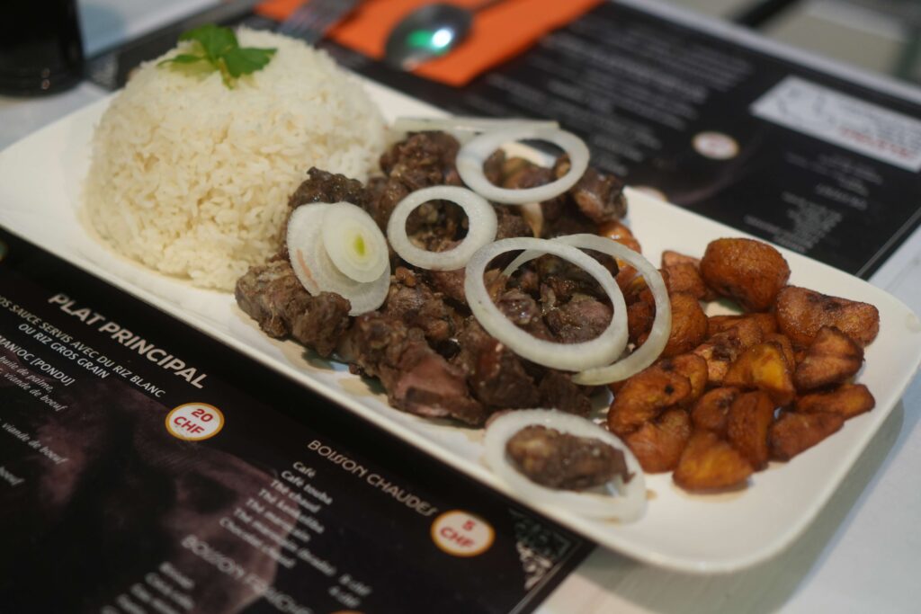 Traditional West African grilled Dibi lamb served with rice and fried plantains at Seleyah Restaurant in Geneva