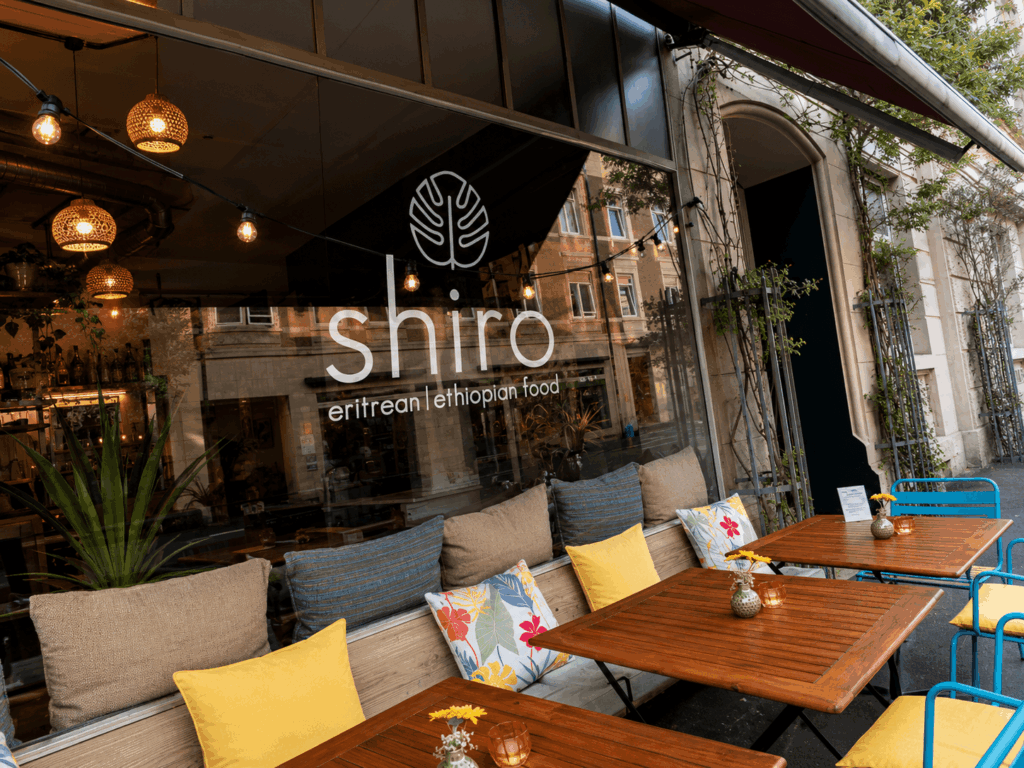 Exterior view of Shiro Basel Ethiopian and Eritrean restaurant in Kleinbasel with inviting terrace seating and warm evening atmosphere