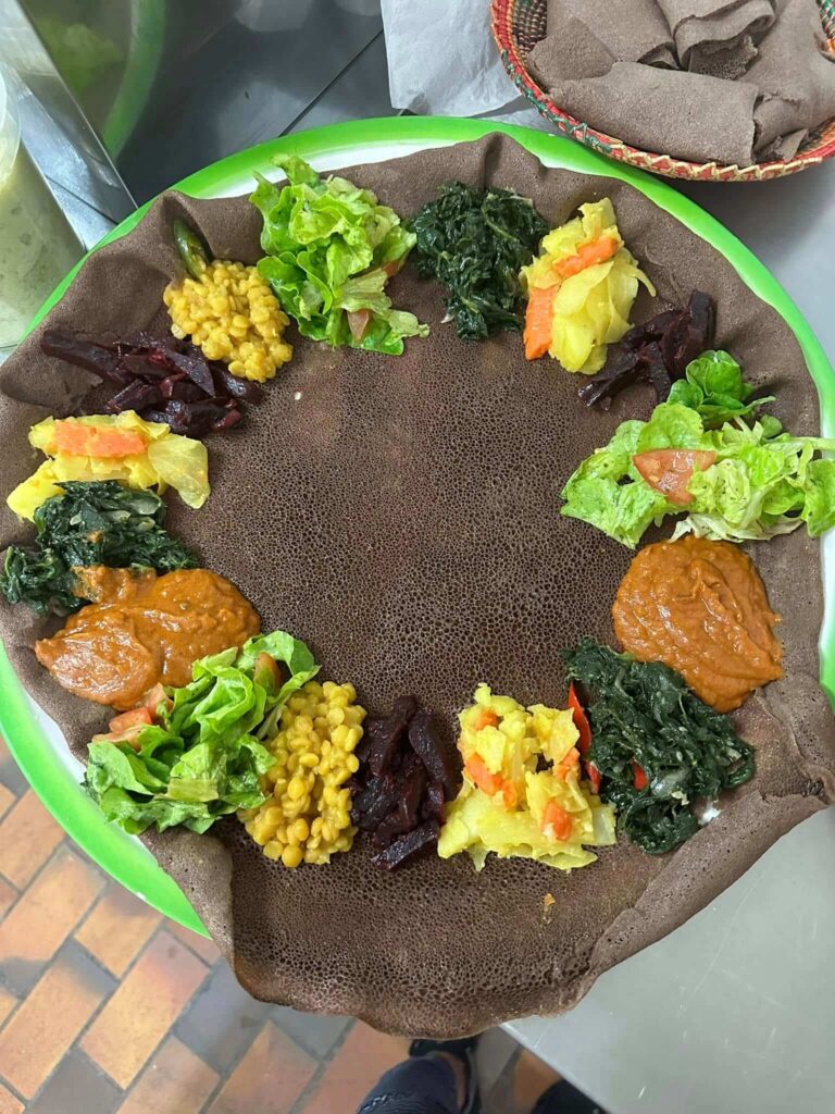 Ethiopian Shiro stew with injera bread, lentils, and fresh vegetable sides at Addis Abeba Restaurant Zürich