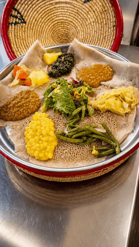 Traditional Ethiopian and Eritrean injera platter with meat, lentils, vegetables, and salad served at Injera Restaurant Bern